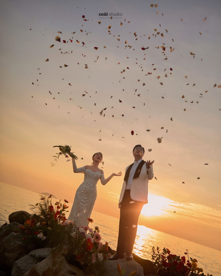Anh và Hưng nắm tay dưới những cánh hoa tung bay trong nắng hoàng hôn ở Hòn Đỏ.