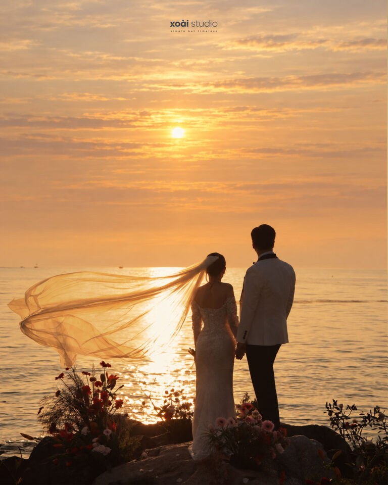 Anh và Hưng đứng ngắm hoàng hôn bên biển Hòn Đỏ, voan cưới bay trong gió.