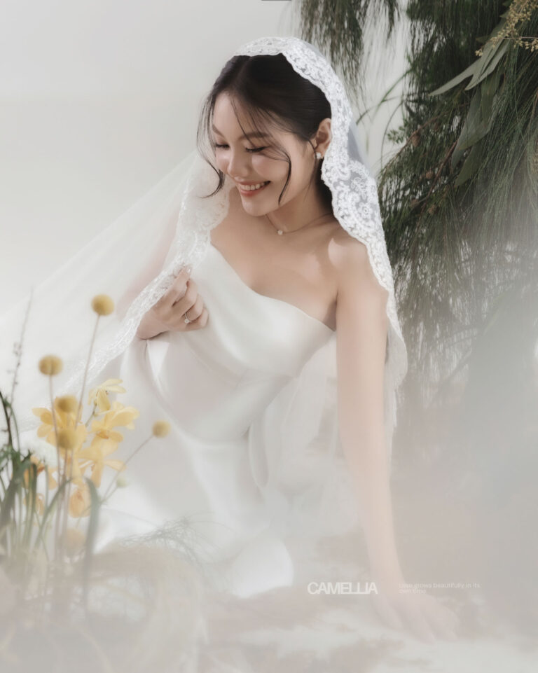 Cận cảnh cô dâu Anh trong váy cưới trắng bên hoa.