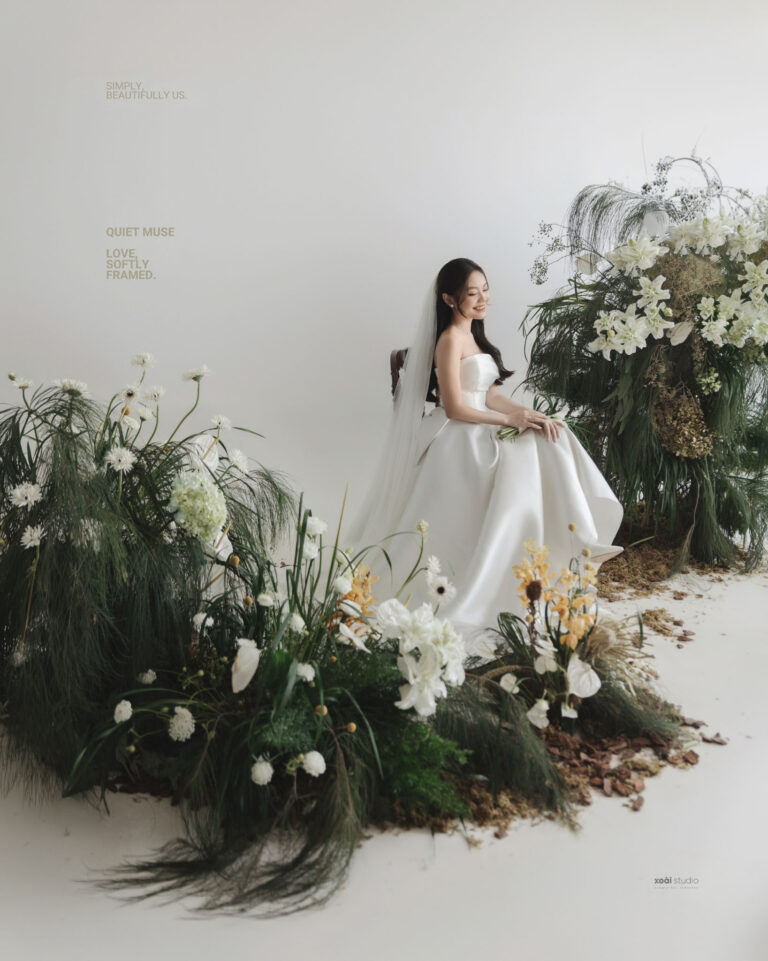 Cô dâu Anh ngồi bên cụm hoa trong ánh sáng cửa sổ.